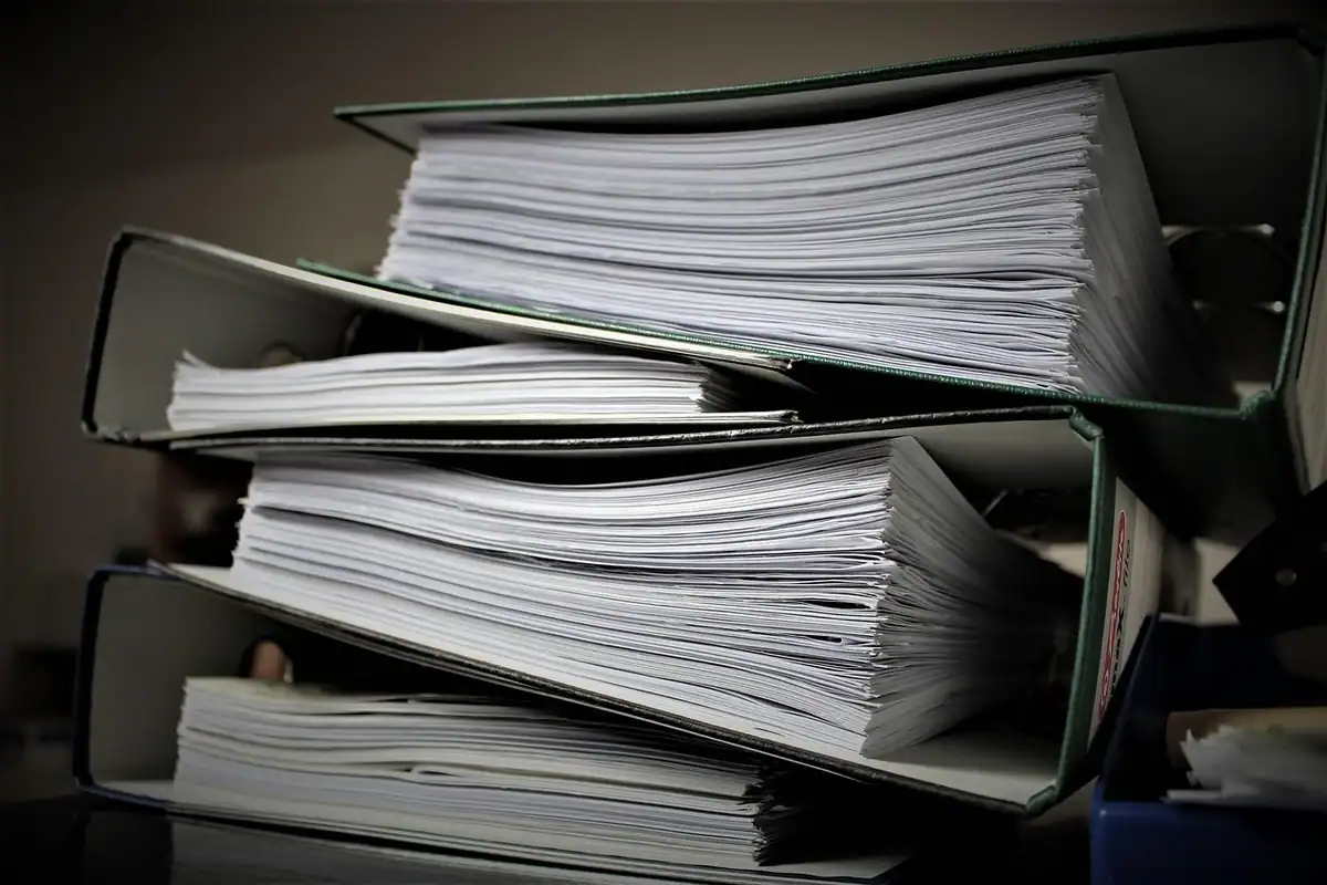 Teanc de dosare cu documente în arhiva unei firme, de unde se eliberează adeverințele