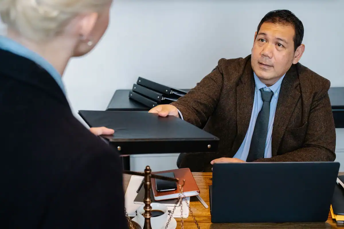 Angajat care primește un dosar cu acte de la manager înainte de plecarea din firmă