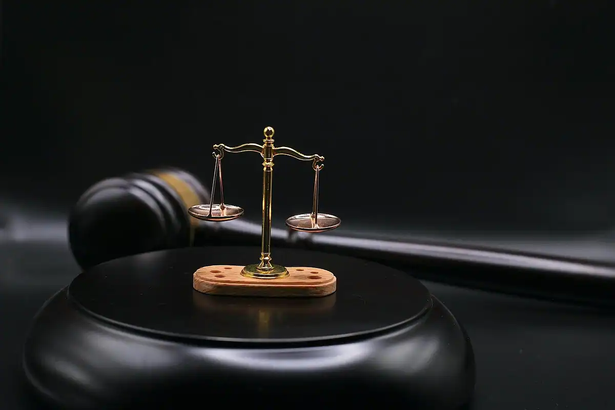 Ciocan de judecător din lemn pe o masă, simbol al unui proces în instanță pentru concediere