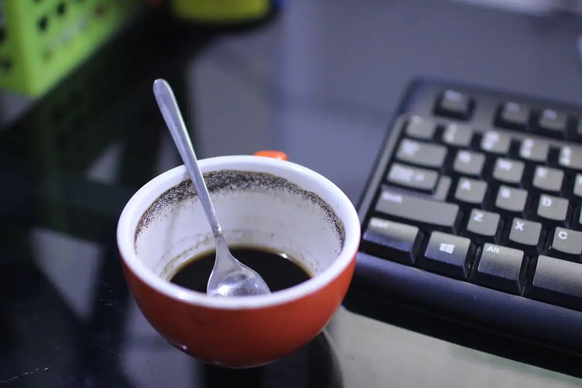 Birou gol cu tastatură și o ceașcă goală de cafea, după plecarea unui angajat