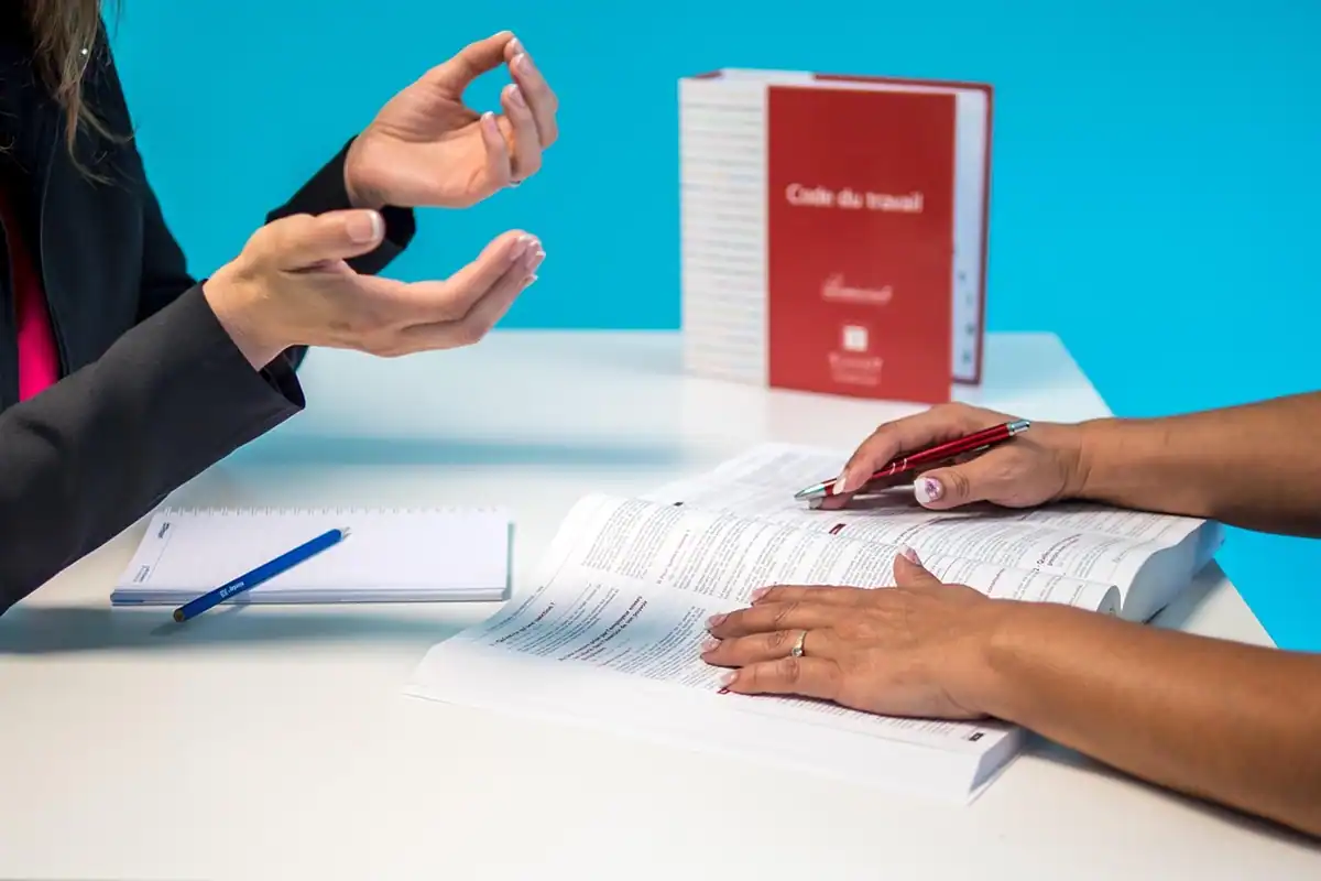 Femeie în sacou roșu la birou, în rolul unui specialist în resurse umane care verifică un contract