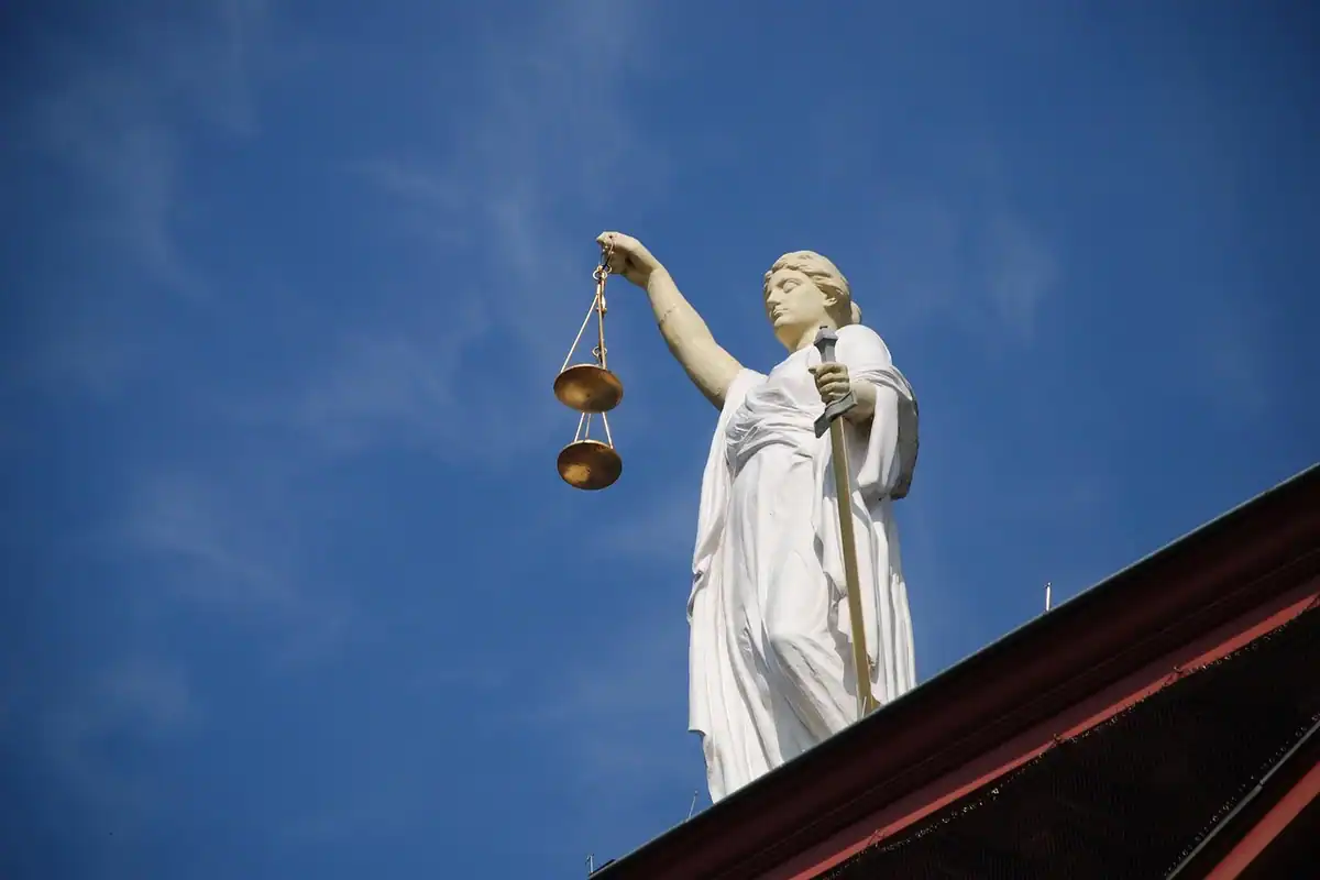 Statuia Justiției cu balanță, ridicată pe cerul albastru, simbol al egalității în drepturi