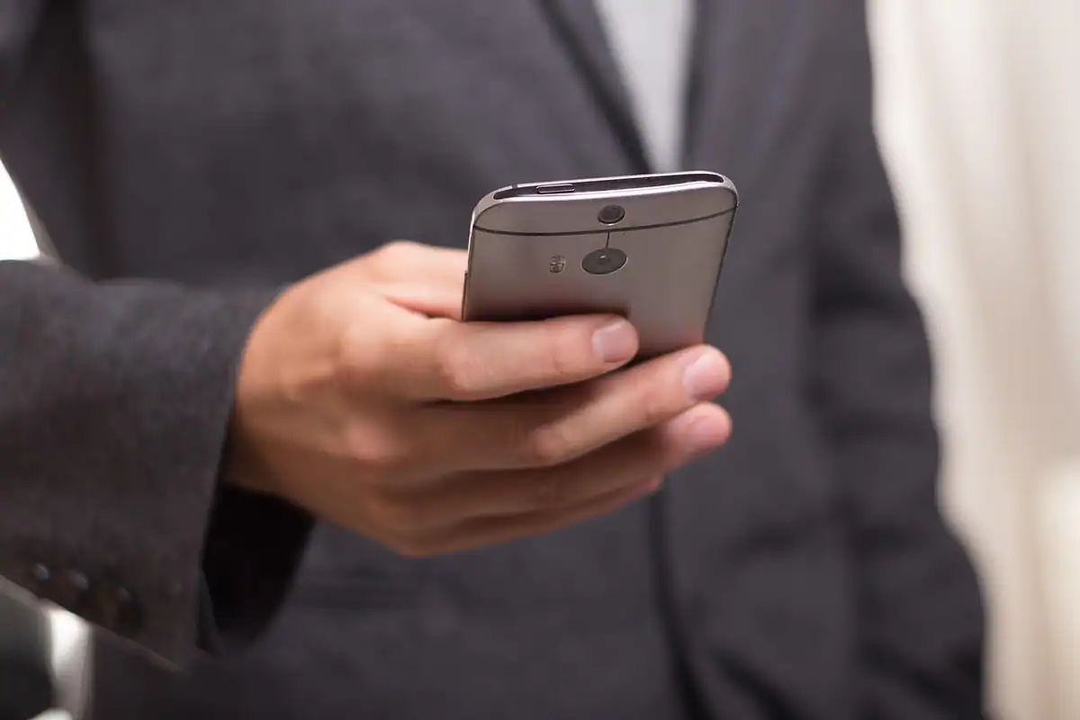 Bărbat în costum care ține un telefon mobil, pentru mesajele folosite ca dovadă