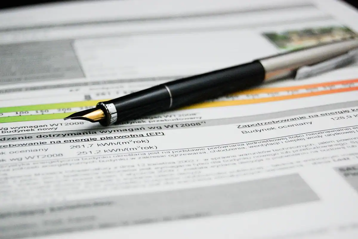 Document semnat cu un pix pe un birou, lângă alte hârtii și o cerere completată