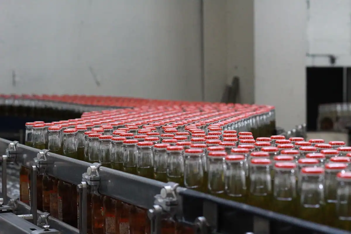 Sticle de sticlă pe o linie de producție dintr-o fabrică, parcurgând etapele de îmbuteliere