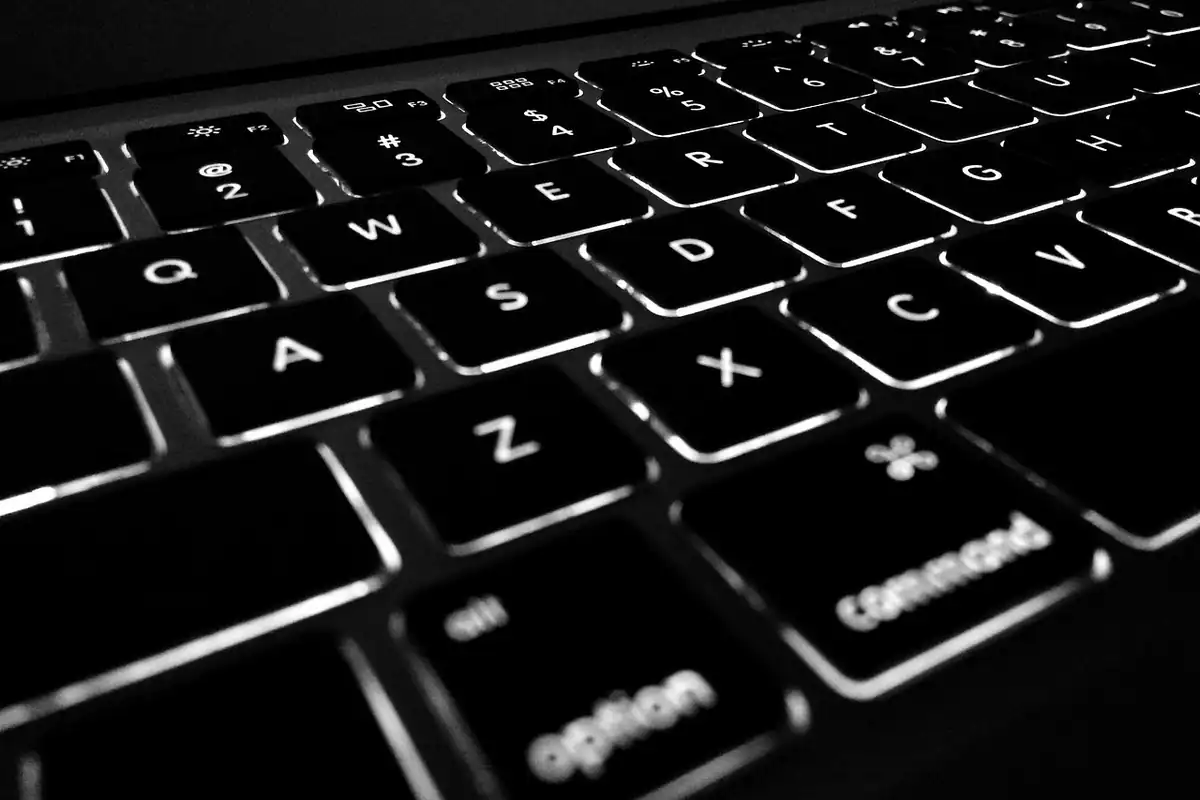 Tastatură iluminată de laptop în alb și negru, într-un plan apropiat, pentru predarea echipamentului