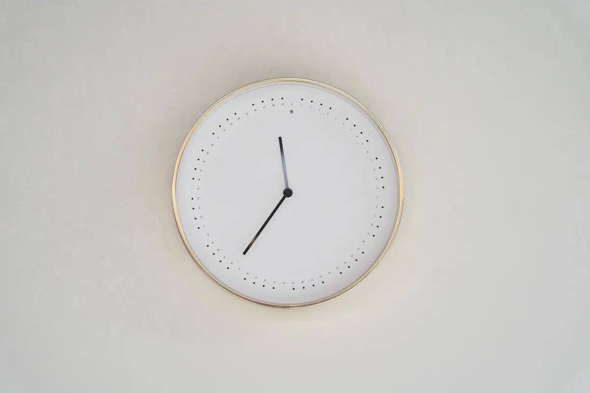 Ceas de perete minimalist cu rama aurie, simbol al programului flexibil