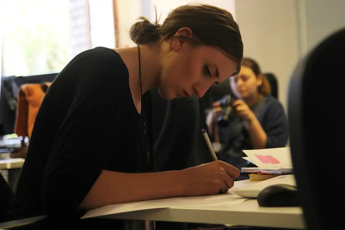 Femeie în birou care studiază atentă niște documente